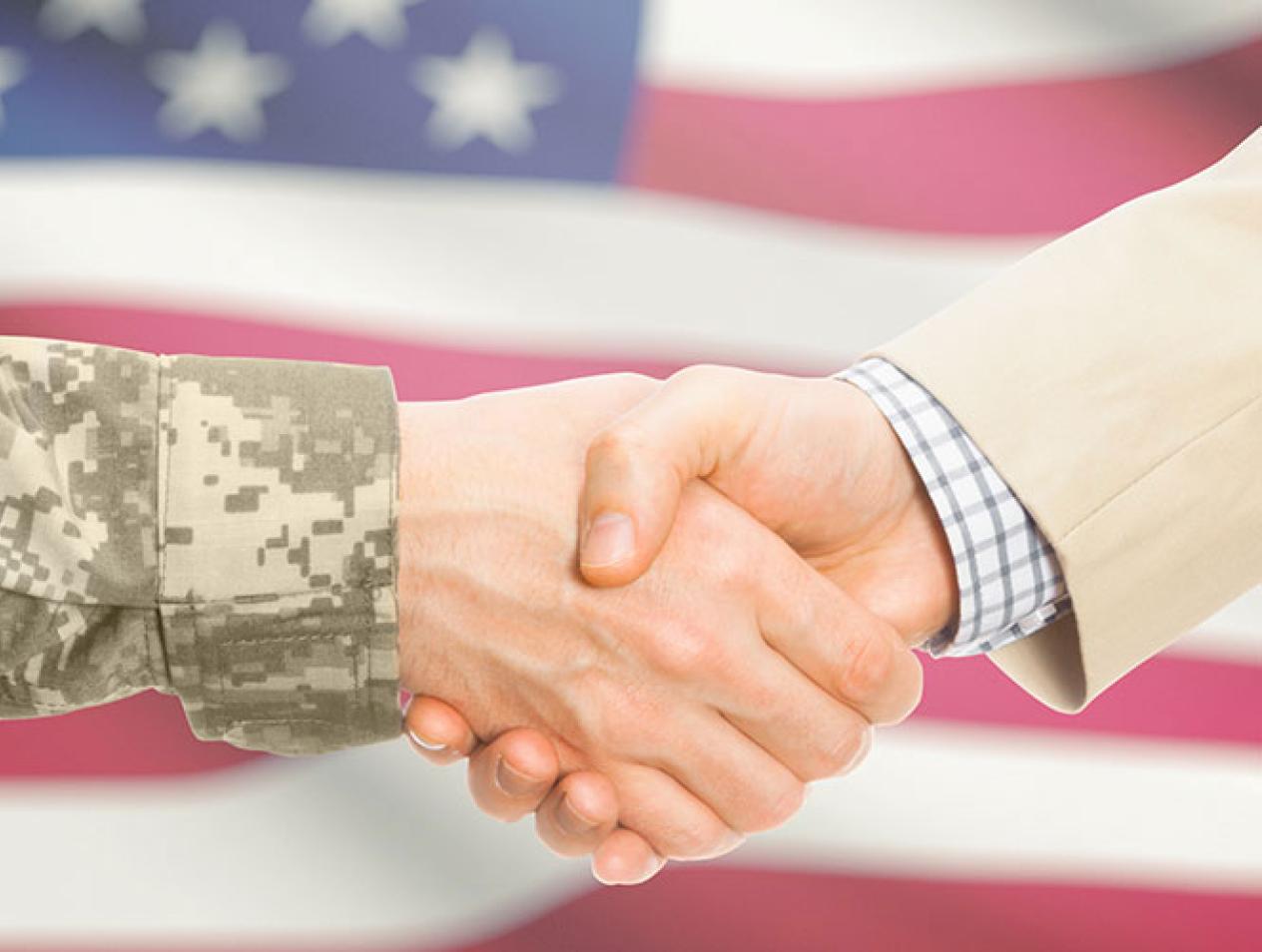 Handshake between uniformed person and person in civilian dress