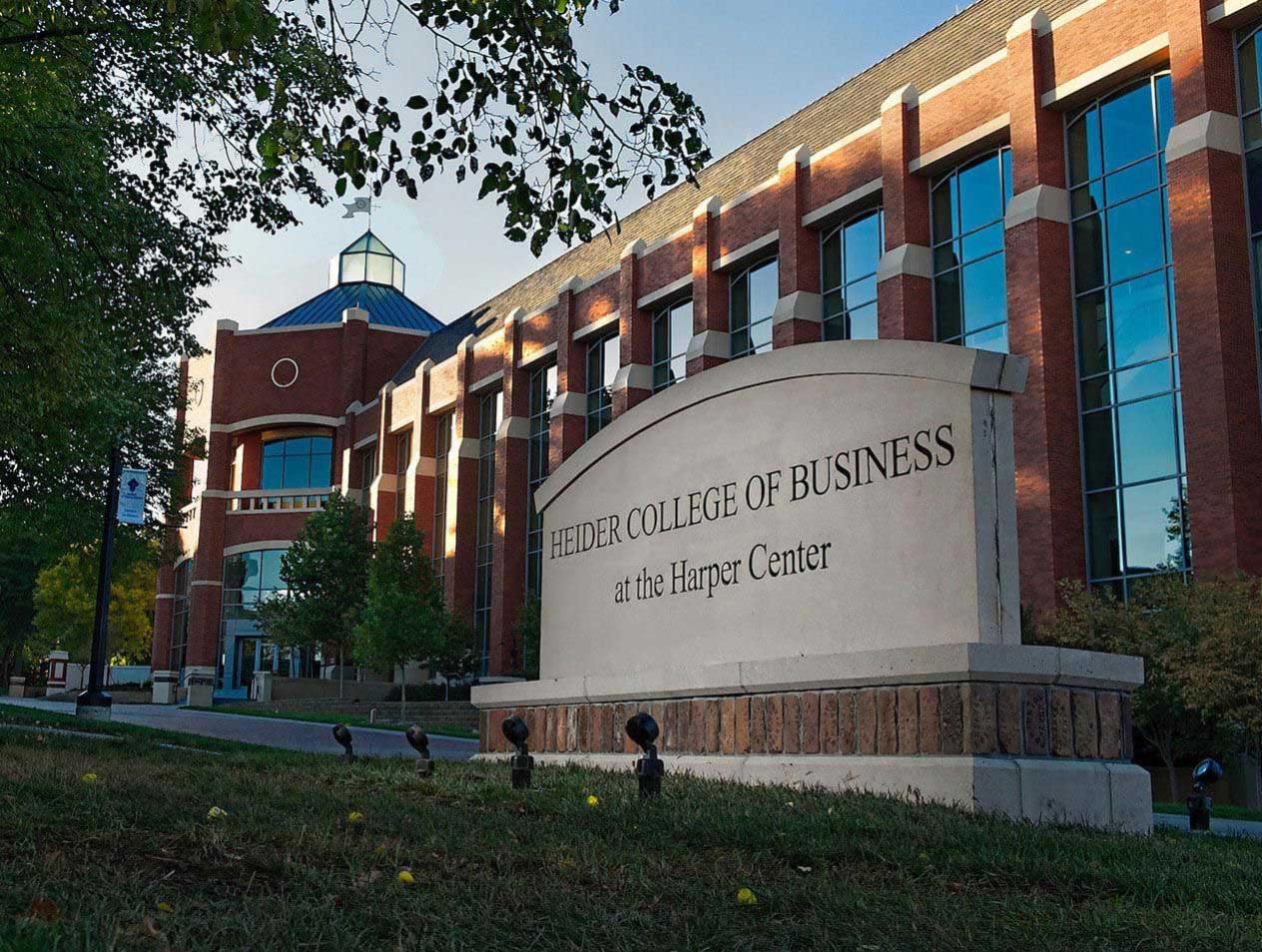 The concrete Heider College of Business sign with Harper Center in the background