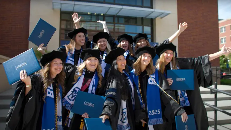 Creighton graduates posing in front of the Ryan Athletic Center
