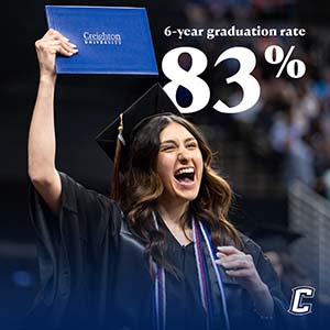 83% graduation rate with student smiling at commencement