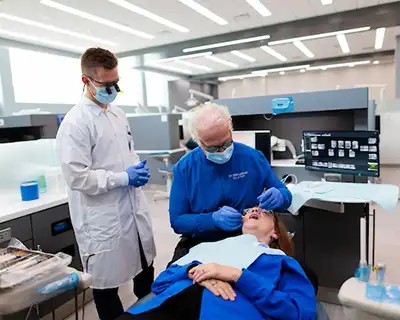 Student learns techniques from instructor in Creighton dental lab.