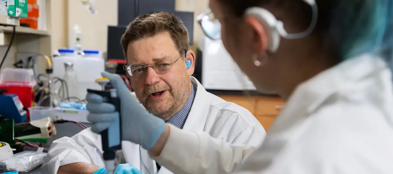 Peter Steyger collaborating with colleague in lab setting.