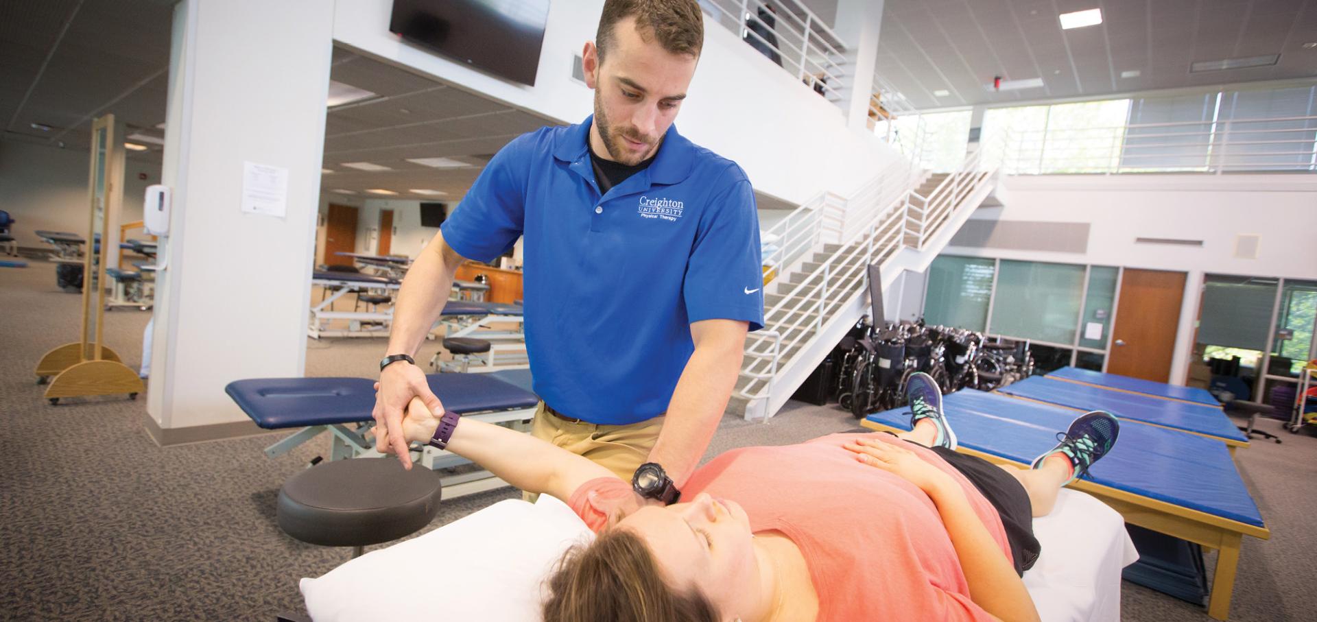 Student performing PT on womans arm