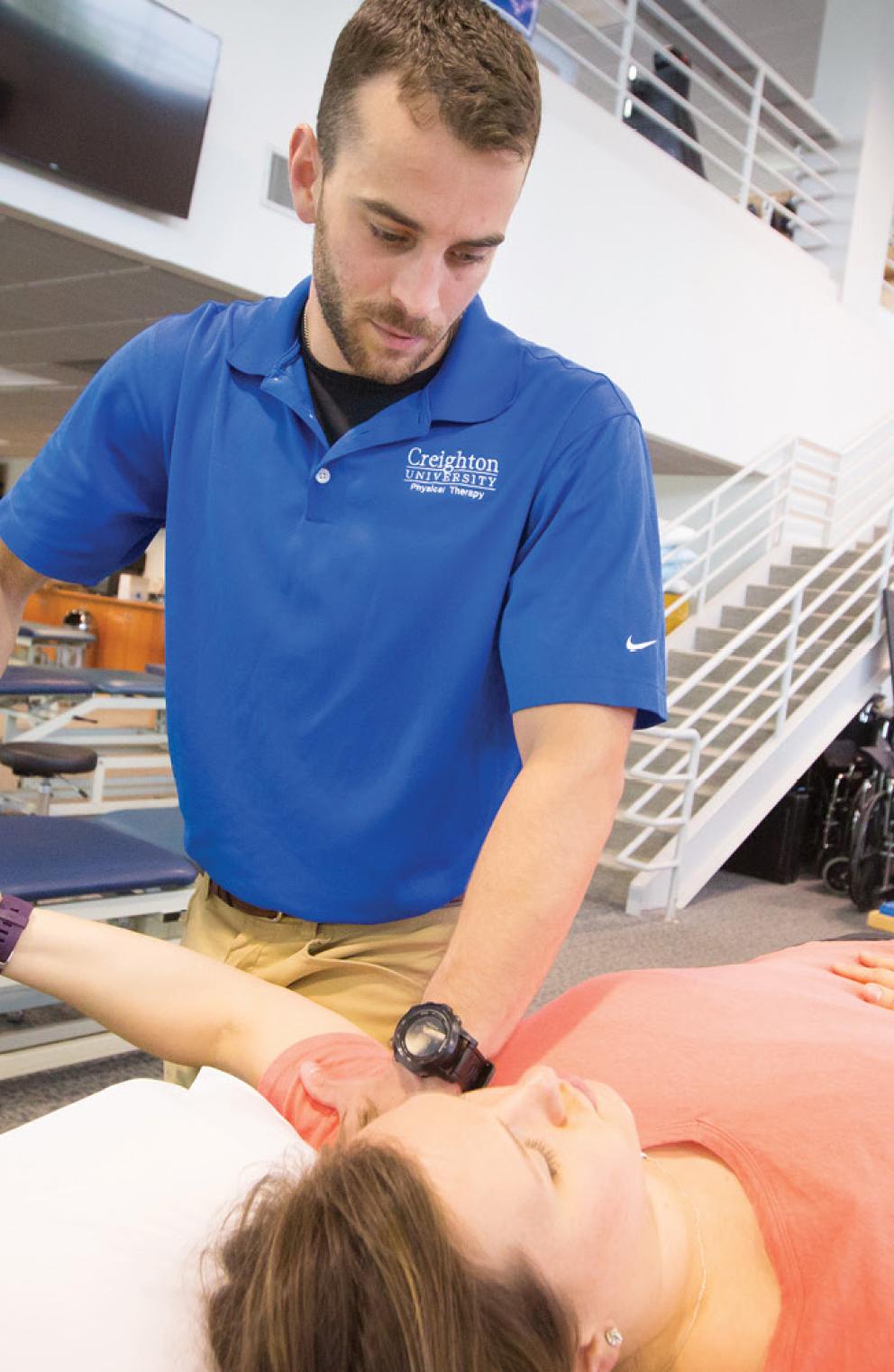 Student performing PT on womans arm