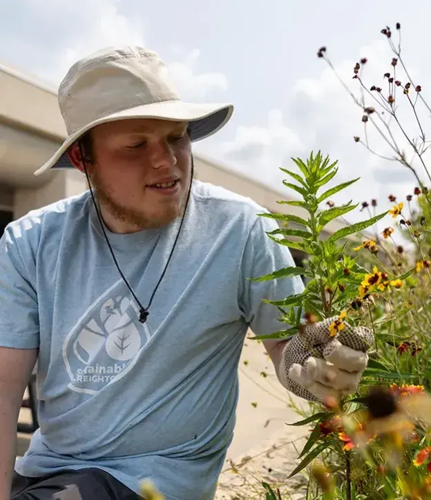 Student in pollinator garden setting.