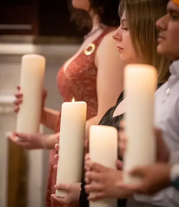 People holding candles at a service.