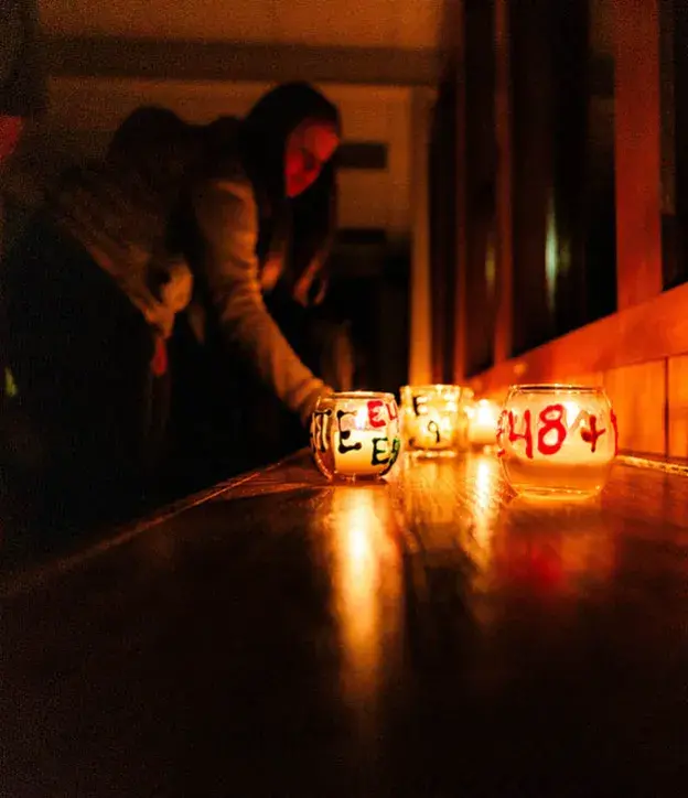 Student in a dark room with candles.