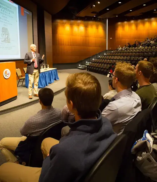 Speaker talking in Harper Center auditorium.