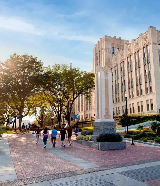 Creighton students walking on mall in morning light.
