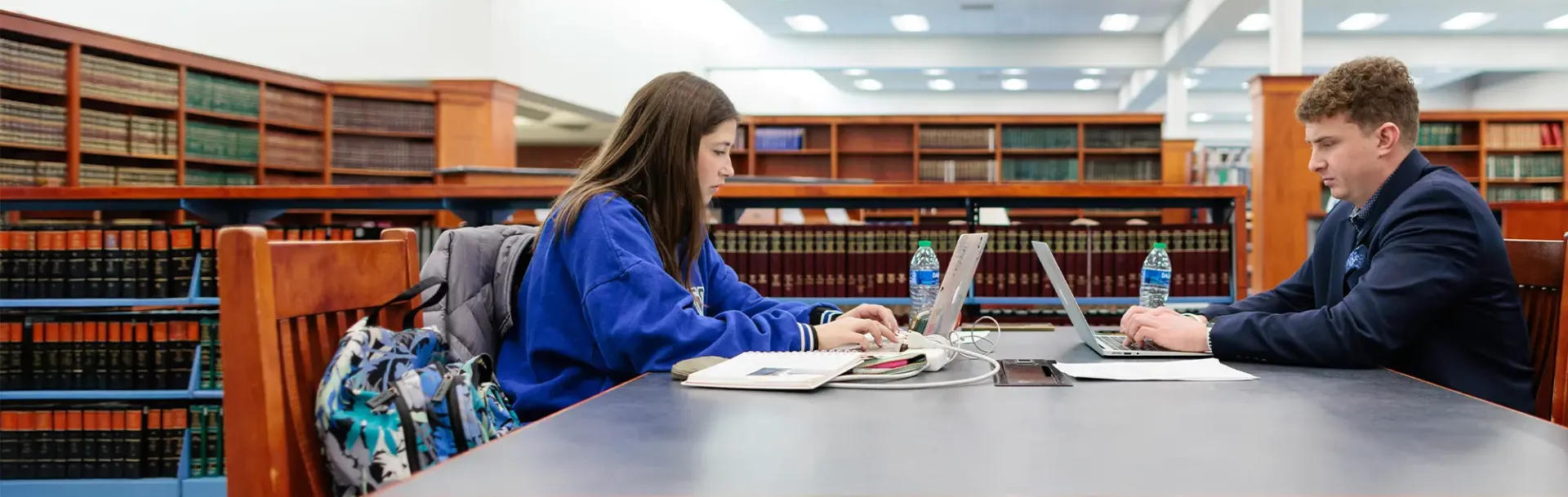 Two students on laptops in Law Library.