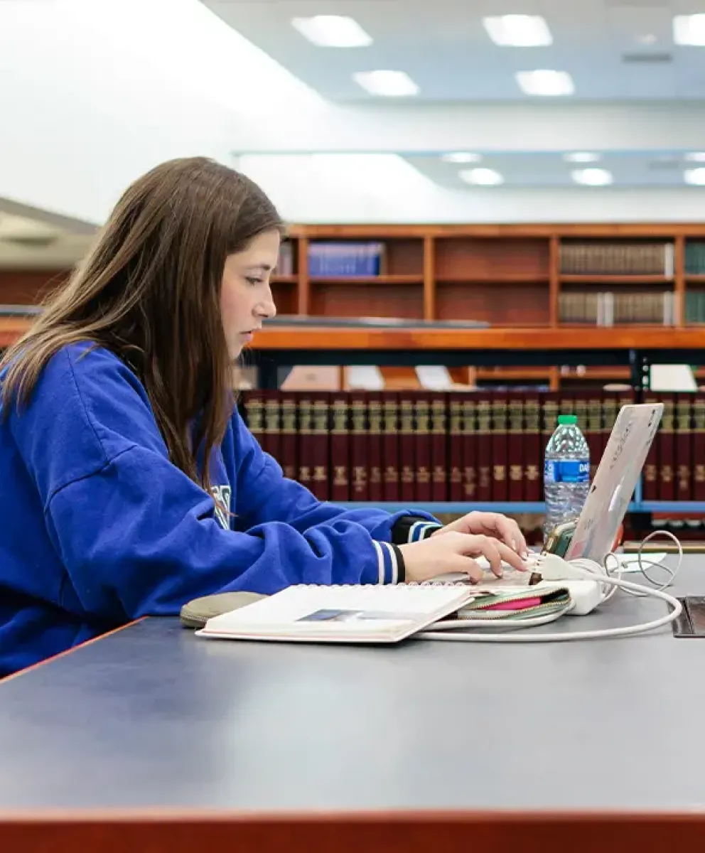 Two students on laptops in Law Library.