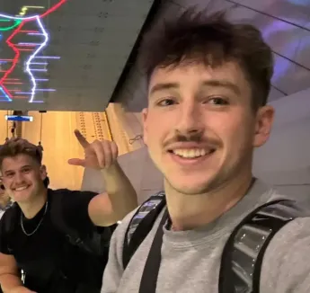 Students on escalator with colorful lighting.