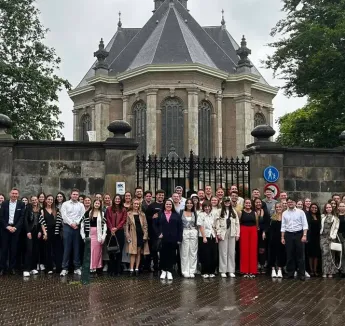 Students posing in group picture on rainy day.