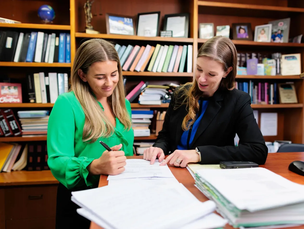 Two women examining plans at table.