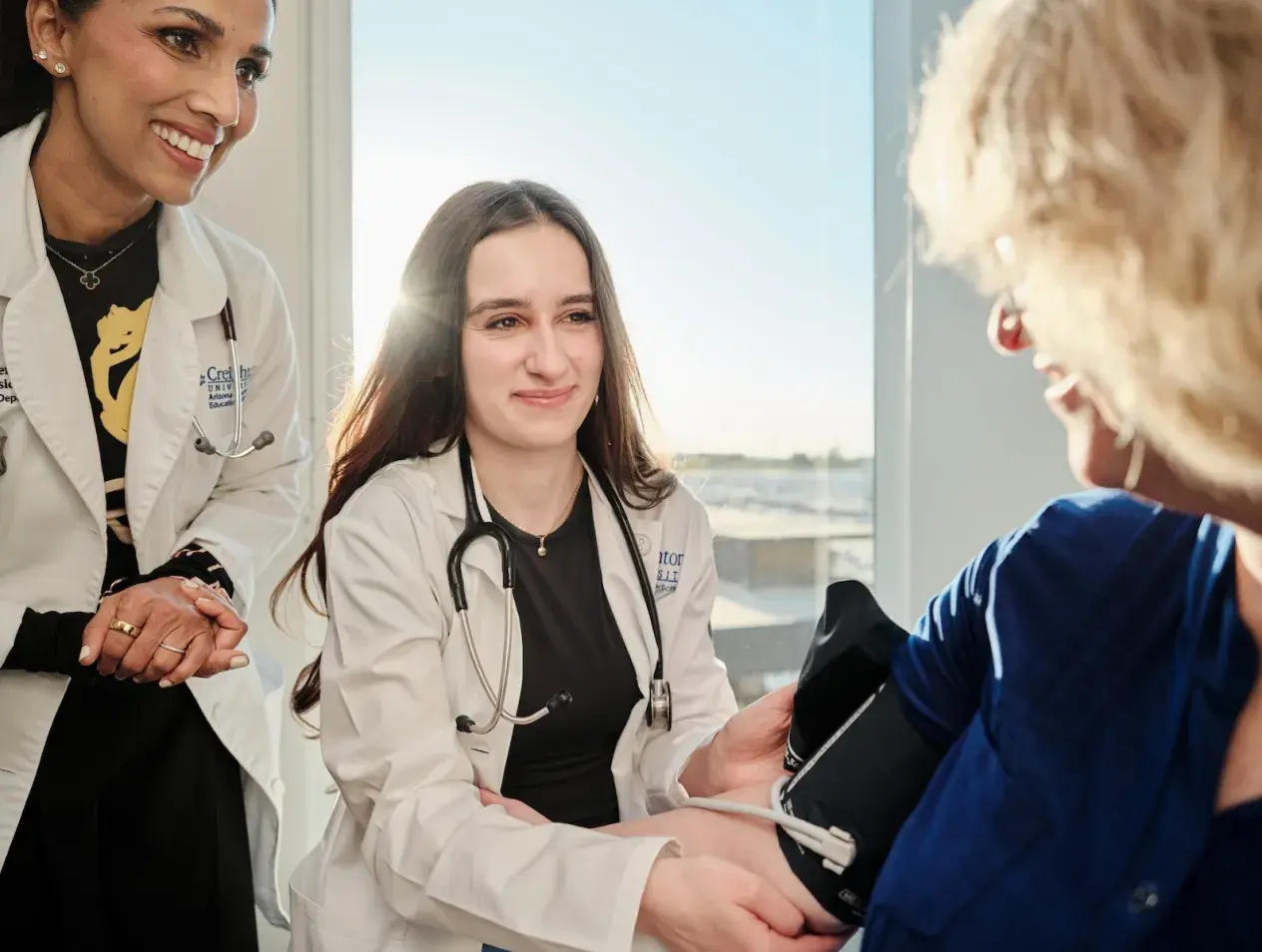 Medical student taking a patient's blood pressure.