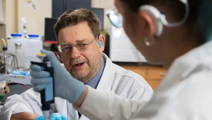 Peter Steyger collaborating with colleague in lab setting.