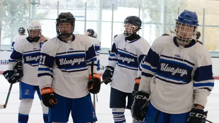 Bluejay hockey players skate to the bench.