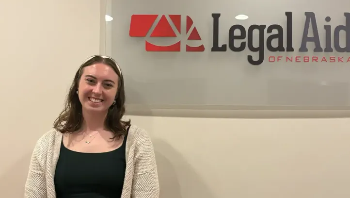 Sarah Crowley standing near Legal Aid of Nebraska sign.