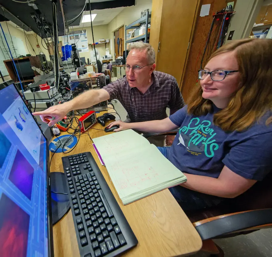 Physics faculty working with student