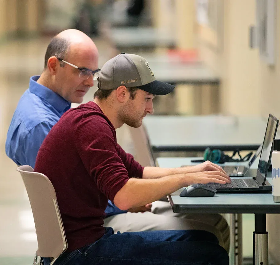 Physics faculty and student working tongether at laptop