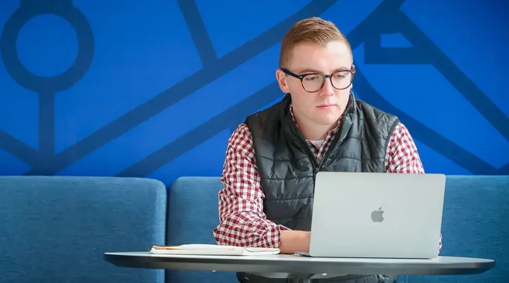 Student using laptop at table