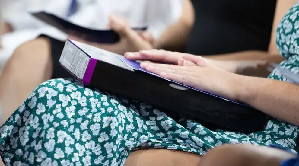 Woman with hands on book.