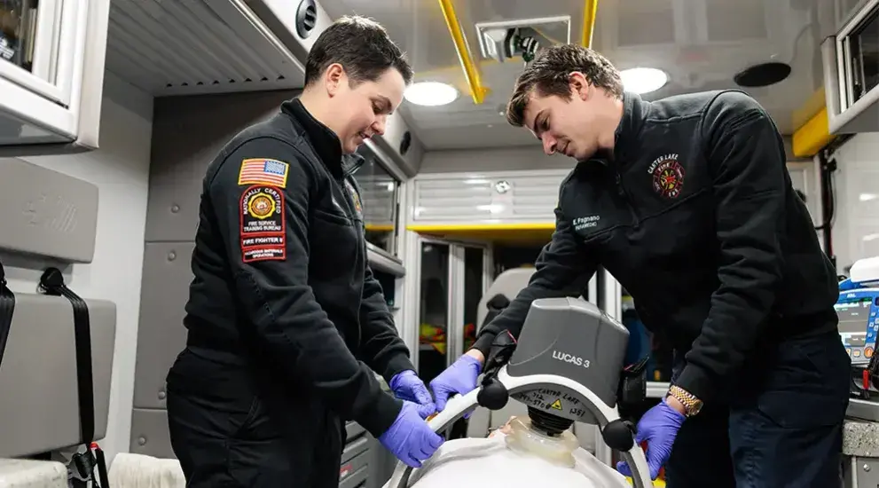 Two EMTs working with medical equipment